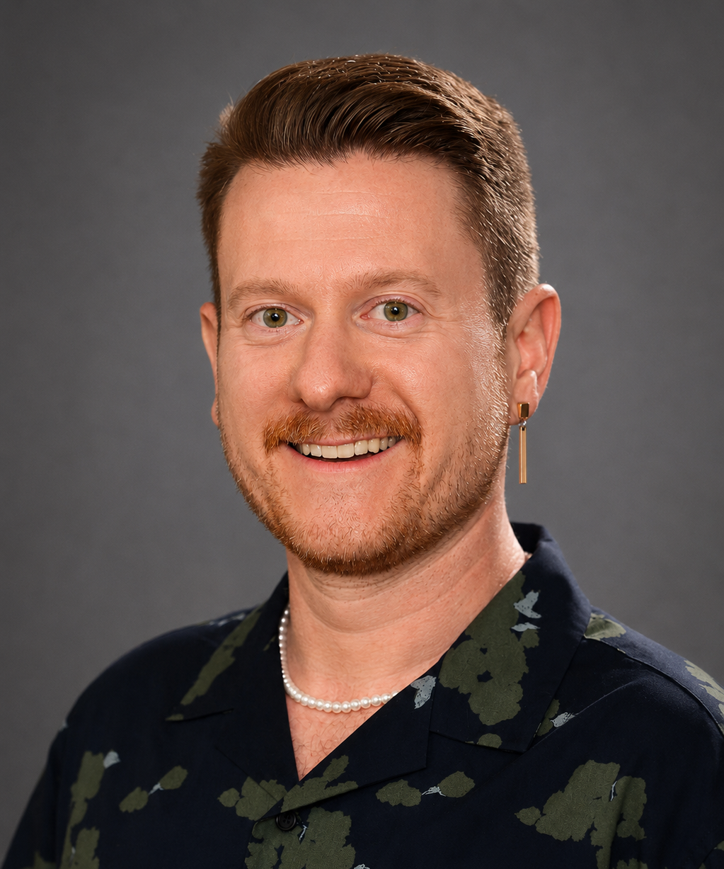 A photograph of Mr. Evan Walsh, wearing a green floral shirt that makes his green eyes pop!