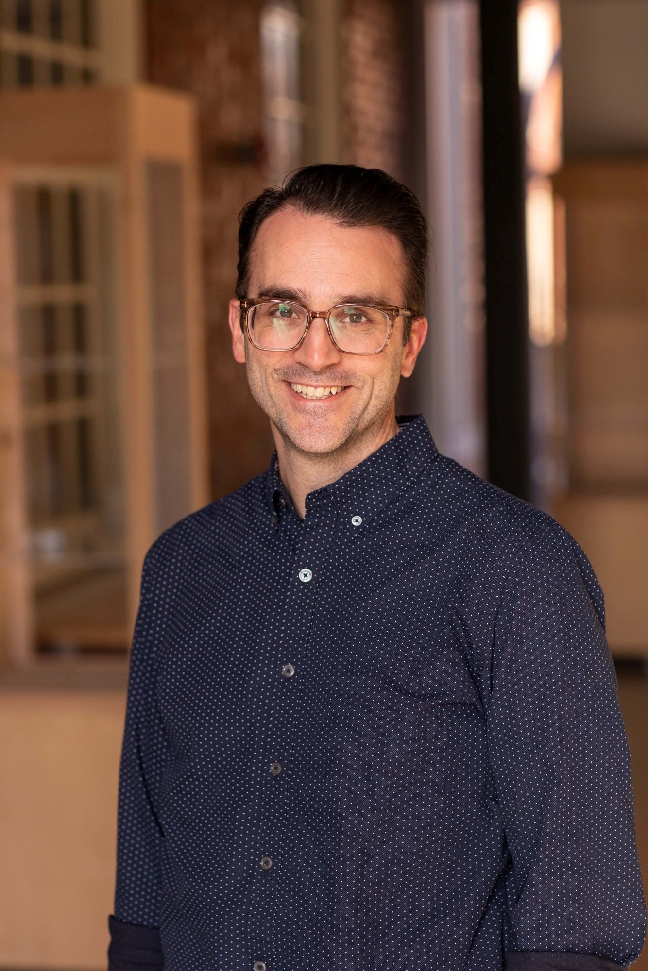 A demure yet sophisticated headshot of Bryan McGrath, GCC's Secretary, with a blurred yet sophisticated background